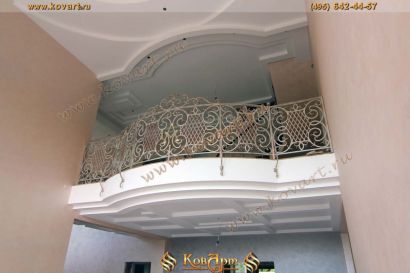 Изогнутый кованый балкон белого цвета с золотой патиной