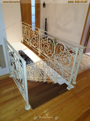 Лестница с коваными узорчатыми перилами белого цвета